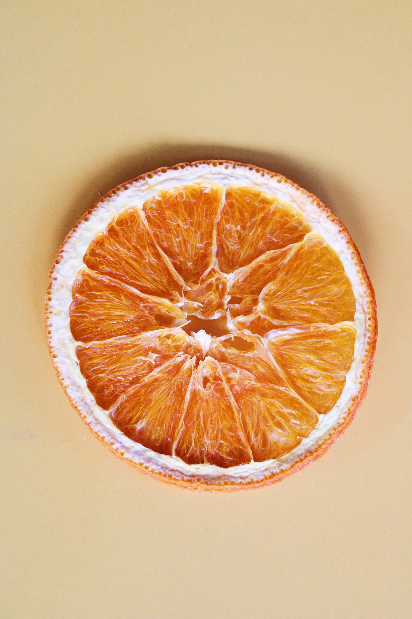 Dehydrated orange wheels garnish for cocktails on beige background