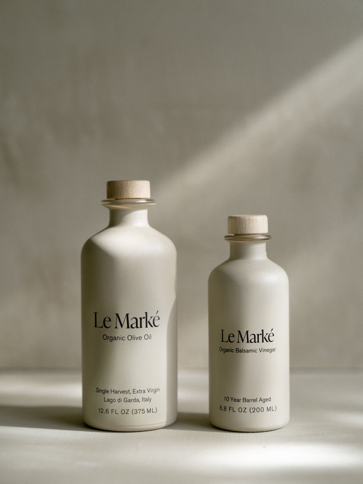 Two Le Marké bottles: Organic Olive Oil and Organic Balsamic Vinegar with wooden corks.