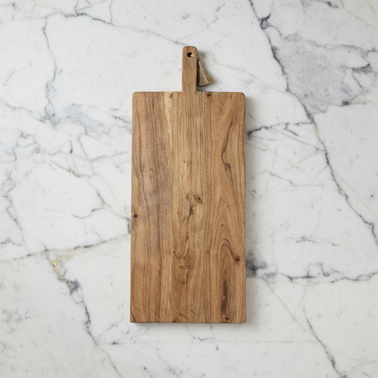Prairie Oversized Acacia Wood Board with handle and tassel, vintage paddle-style serving board on marble surface