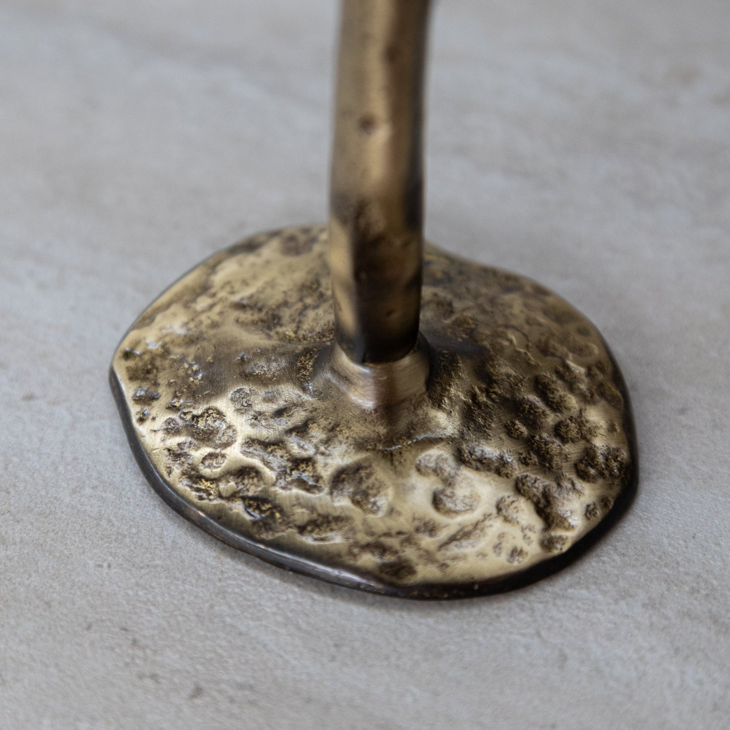 Base of antique brass candlestick with hammered finish, part of a hand-forged set of three.