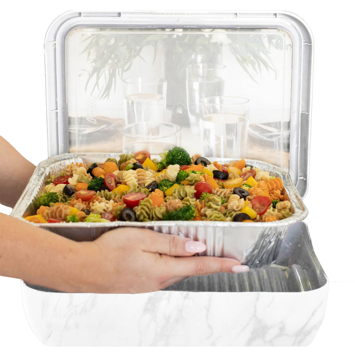 Marble foil pan carrier frame with clear lid holding a pasta salad, designed for sturdy transport and serving.