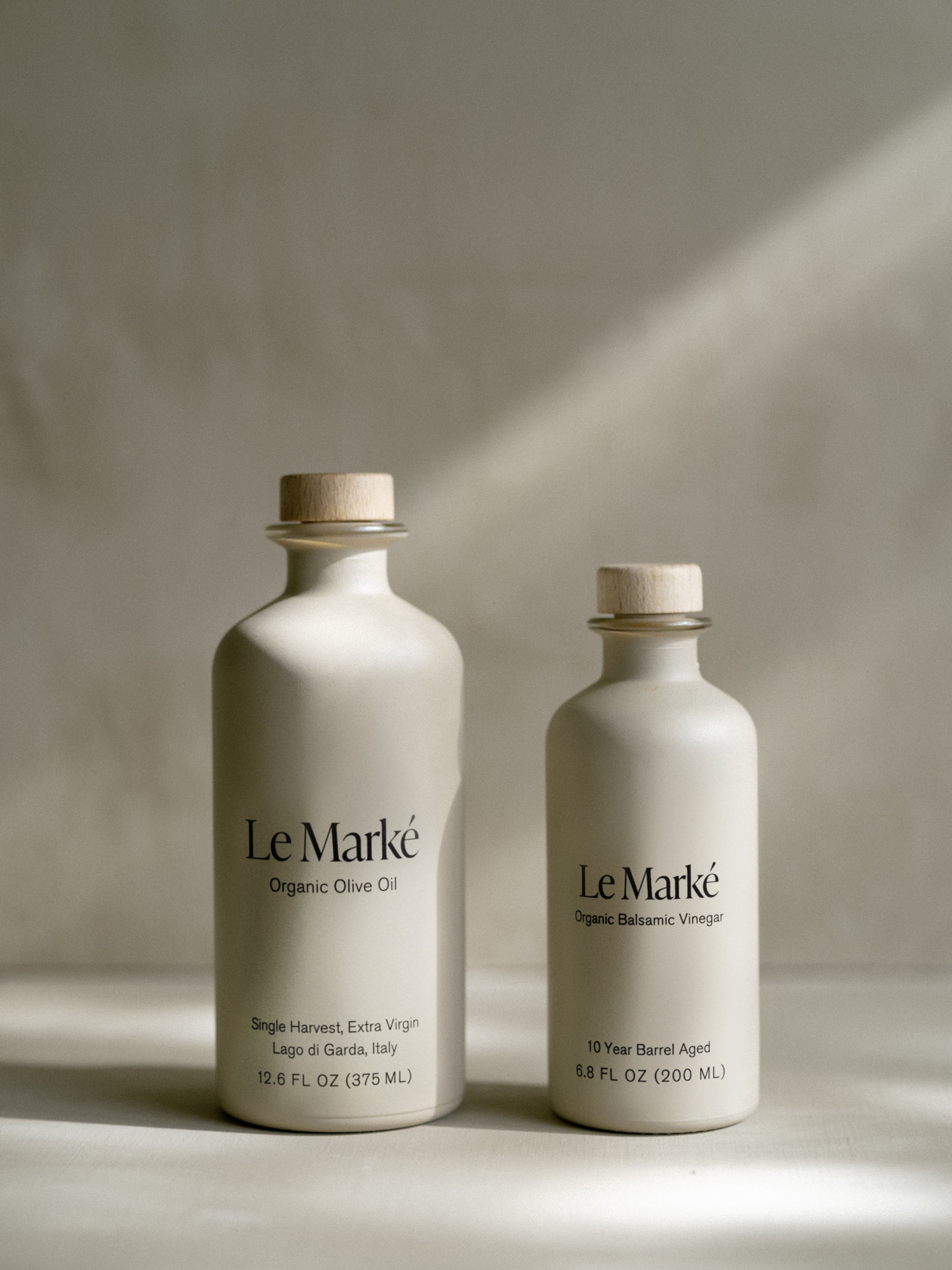 Two Le Marké bottles: Organic Olive Oil and Organic Balsamic Vinegar with wooden corks.