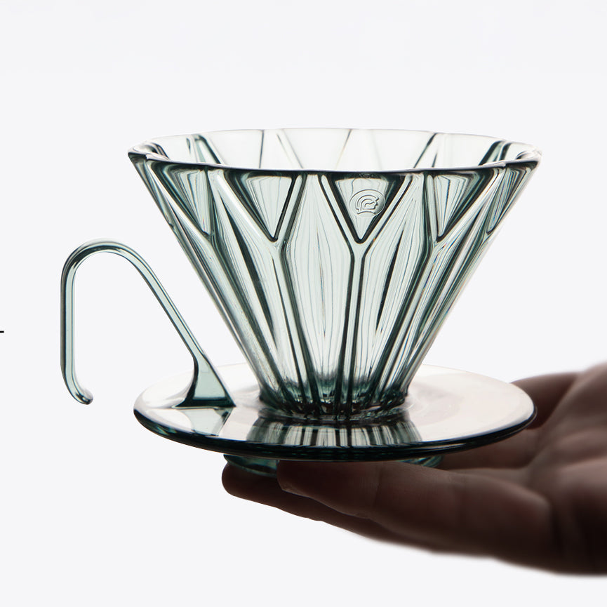 Diamond Pattern Prisma Pour Over Coffee Dripper in clear PCTG glass with saucer, held by hand
