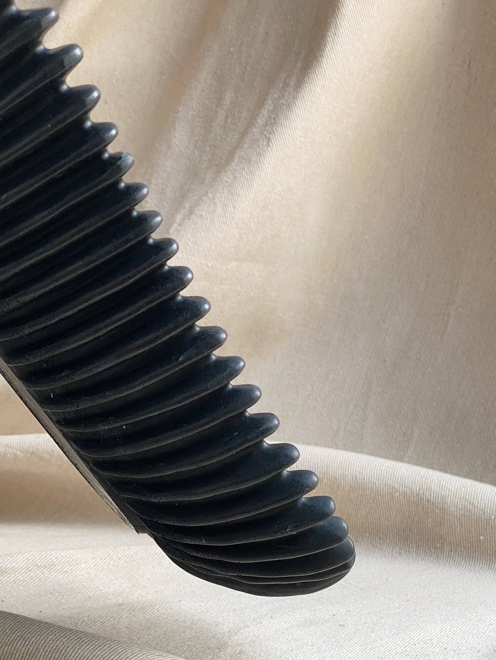 Black FORMA handmade concrete oval bowl with ribbed exterior, decorative centerpiece.