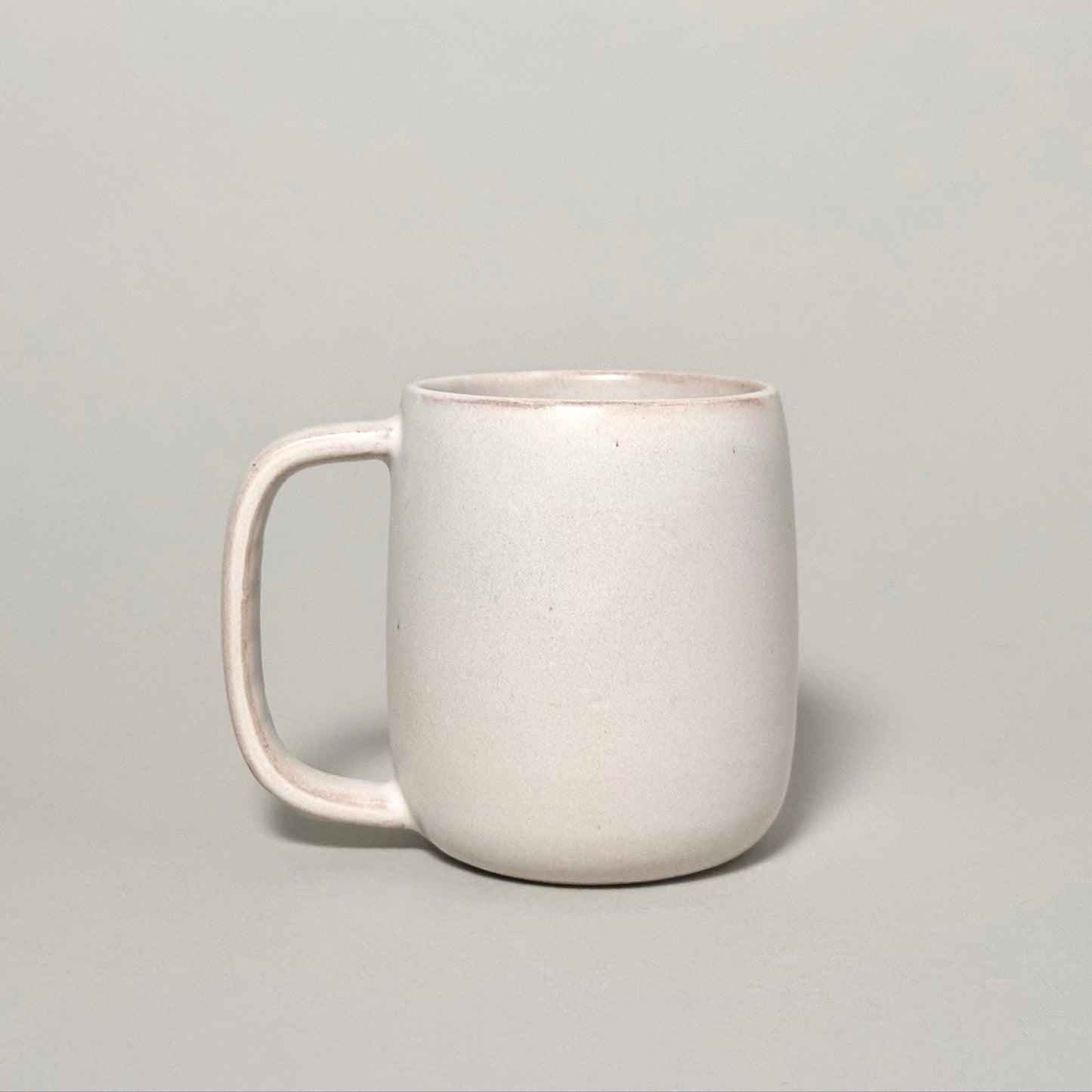 The Standard Mug, a 12oz cream ceramic mug with a rounded body and comfortable handle.