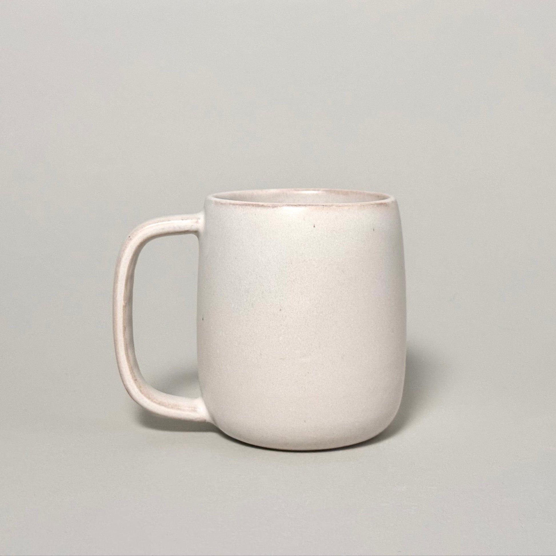 The Standard Mug, a 12oz cream ceramic mug with a rounded body and comfortable handle.