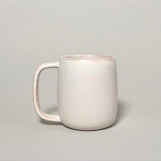 The Standard Mug, a 12oz cream ceramic mug with a rounded body and comfortable handle.