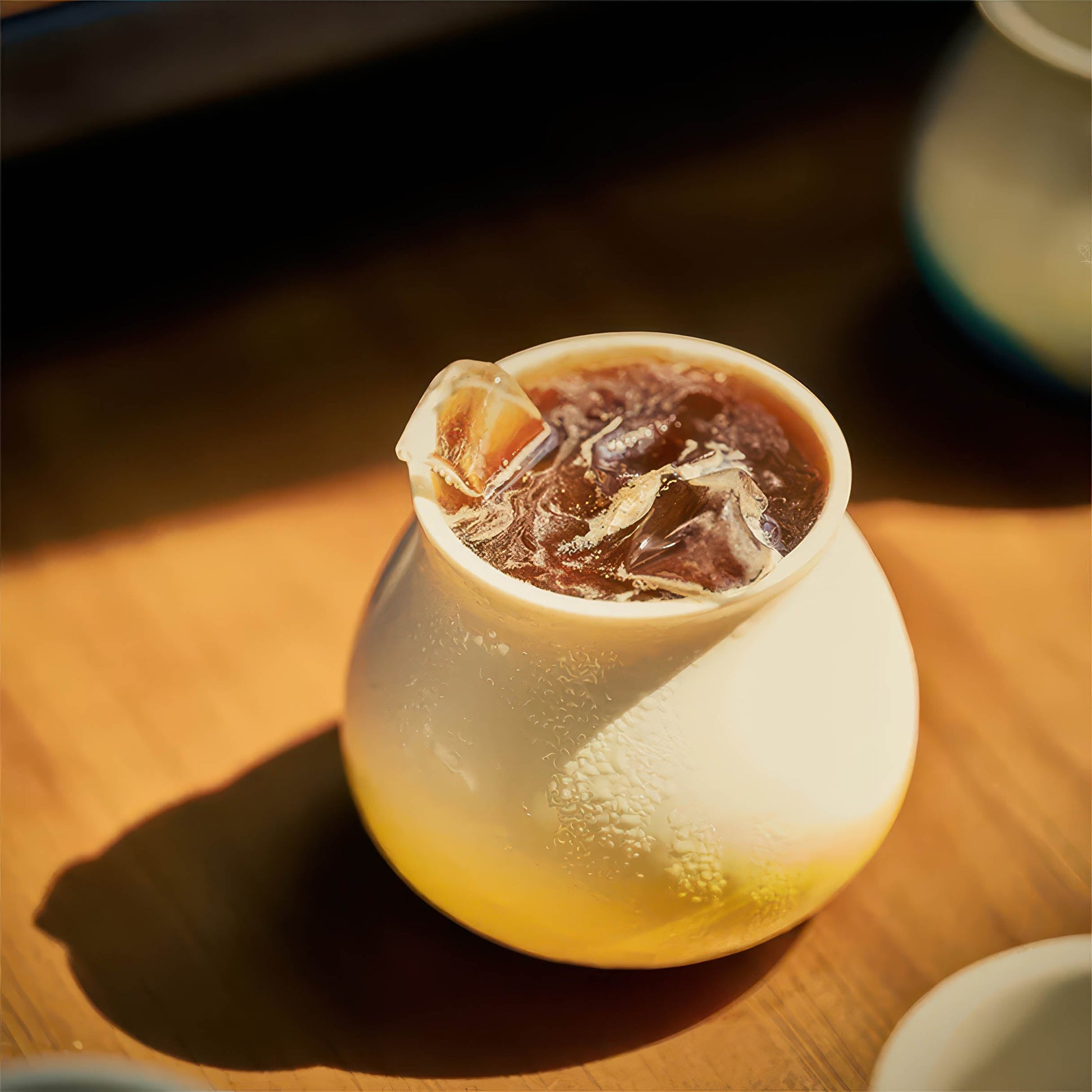 Ceramic Gradient Coffee Cup, 180ml, holds iced coffee with condensation on a wooden surface.