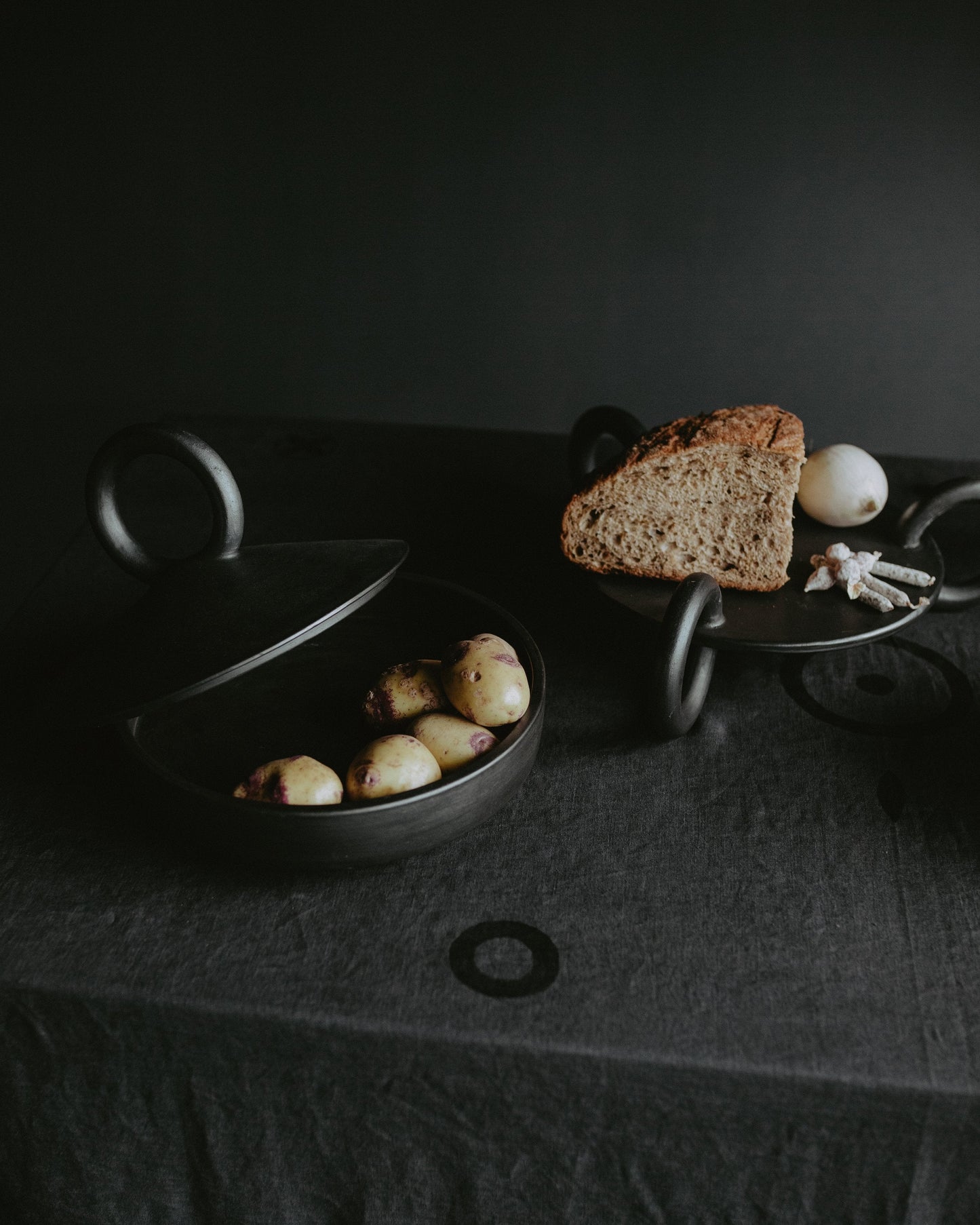 Large Serving Platter Guculia. Trinity shown with rustic bread and potatoes on a dark table.
