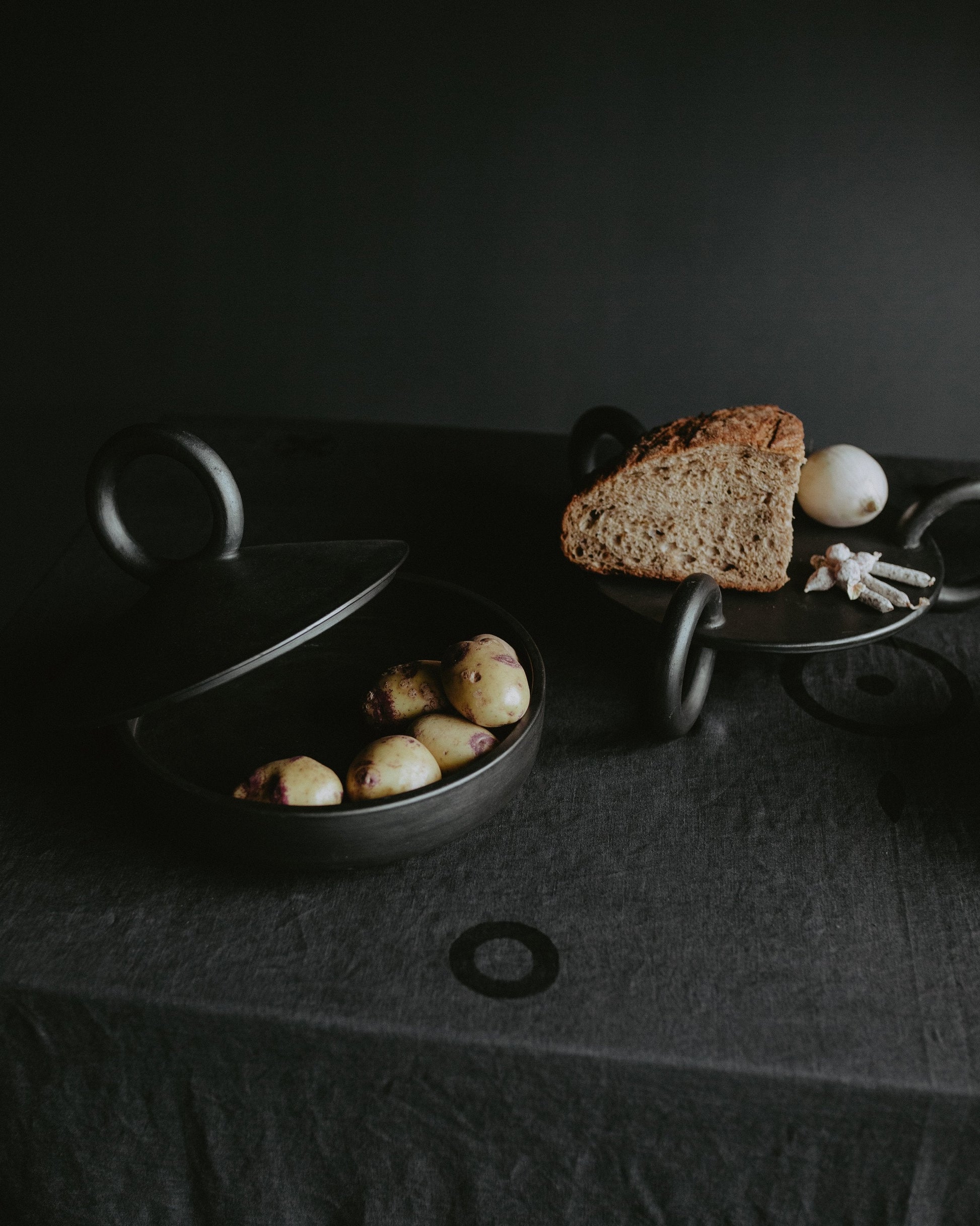 Large Serving Platter Guculia. Trinity shown with rustic bread and potatoes on a dark table.