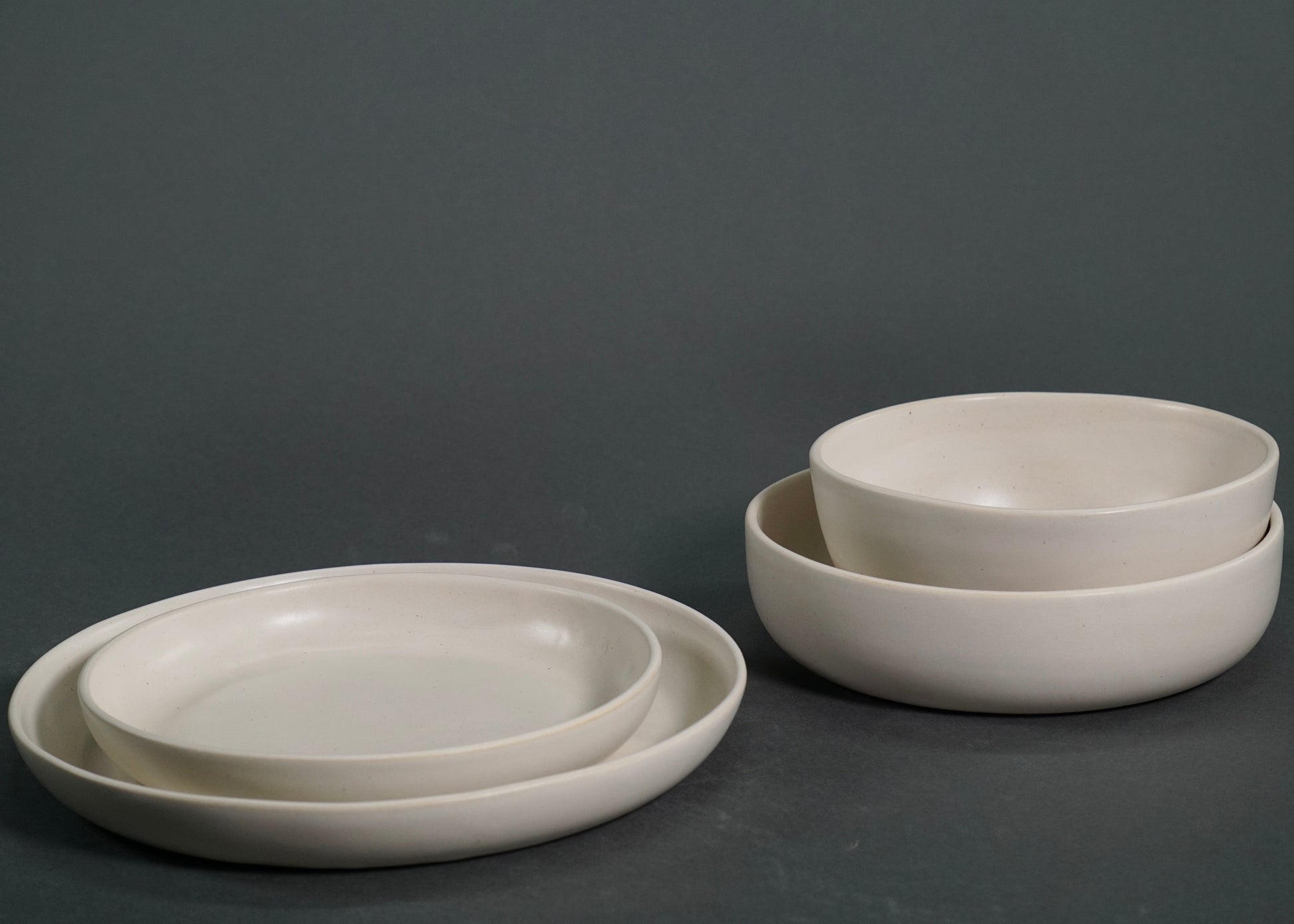 The Dinnerware Set - Ivory: nested plates and bowls in a smooth ivory finish.