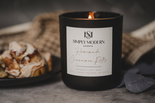 Homemade Cinnamon Rolls coconut soy wax candle in a black jar with a crackling wooden wick.