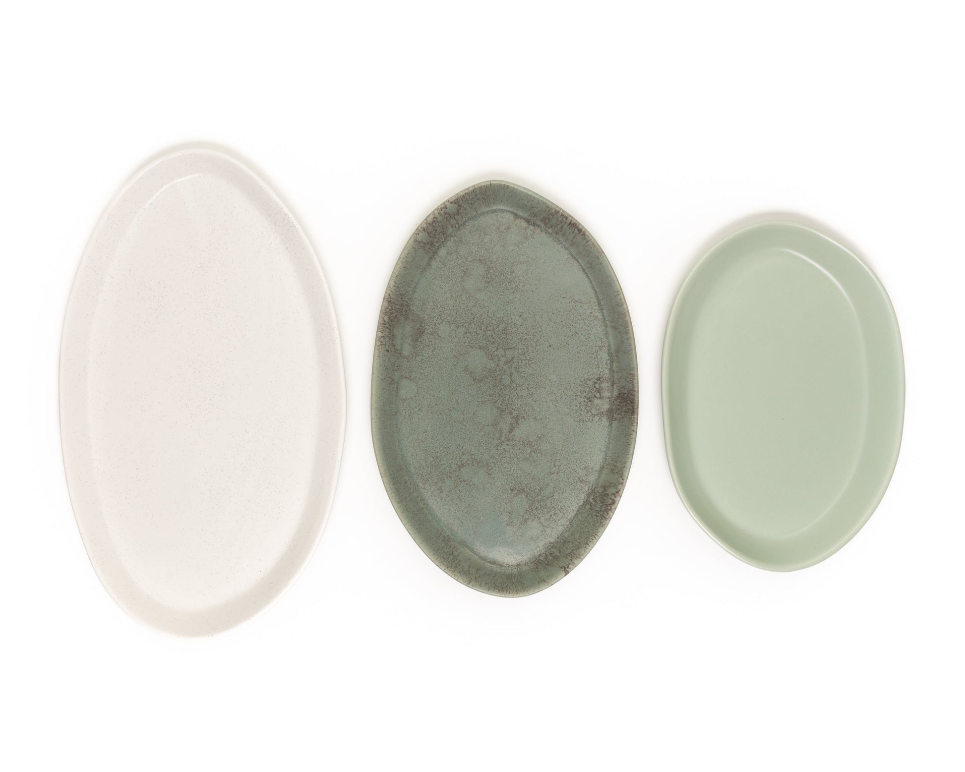 Three oval serving platters in ivory, speckled gray, and sage green in 13", 15", and 18" sizes.