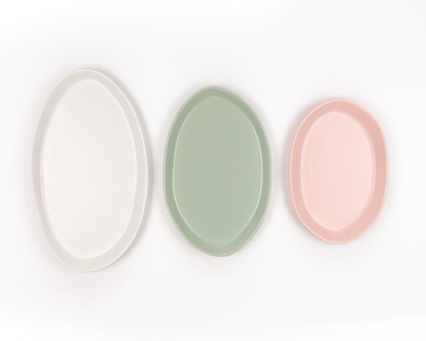 Three oval platters from a 3 Piece Serving Platter Set in white, sage, and blush pink (13, 15, 18 inches).