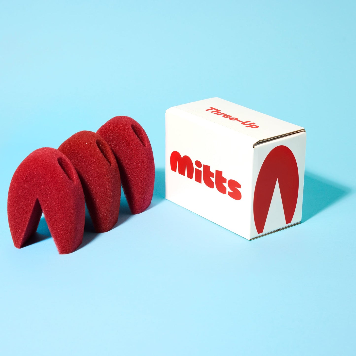 The Three-Up sponges beside a Mitts box, designed to clean delicate stemware and crystal.