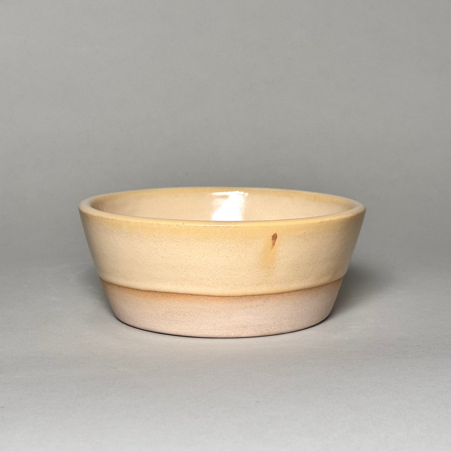 Soup Bowl - 6-inch cream-glazed ceramic two-tone bowl with tan base.