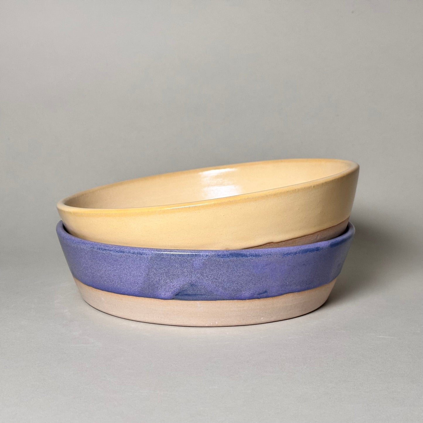 Share Bowl - 9-inch ceramic bowls stacked, beige interior with blue glaze exterior.