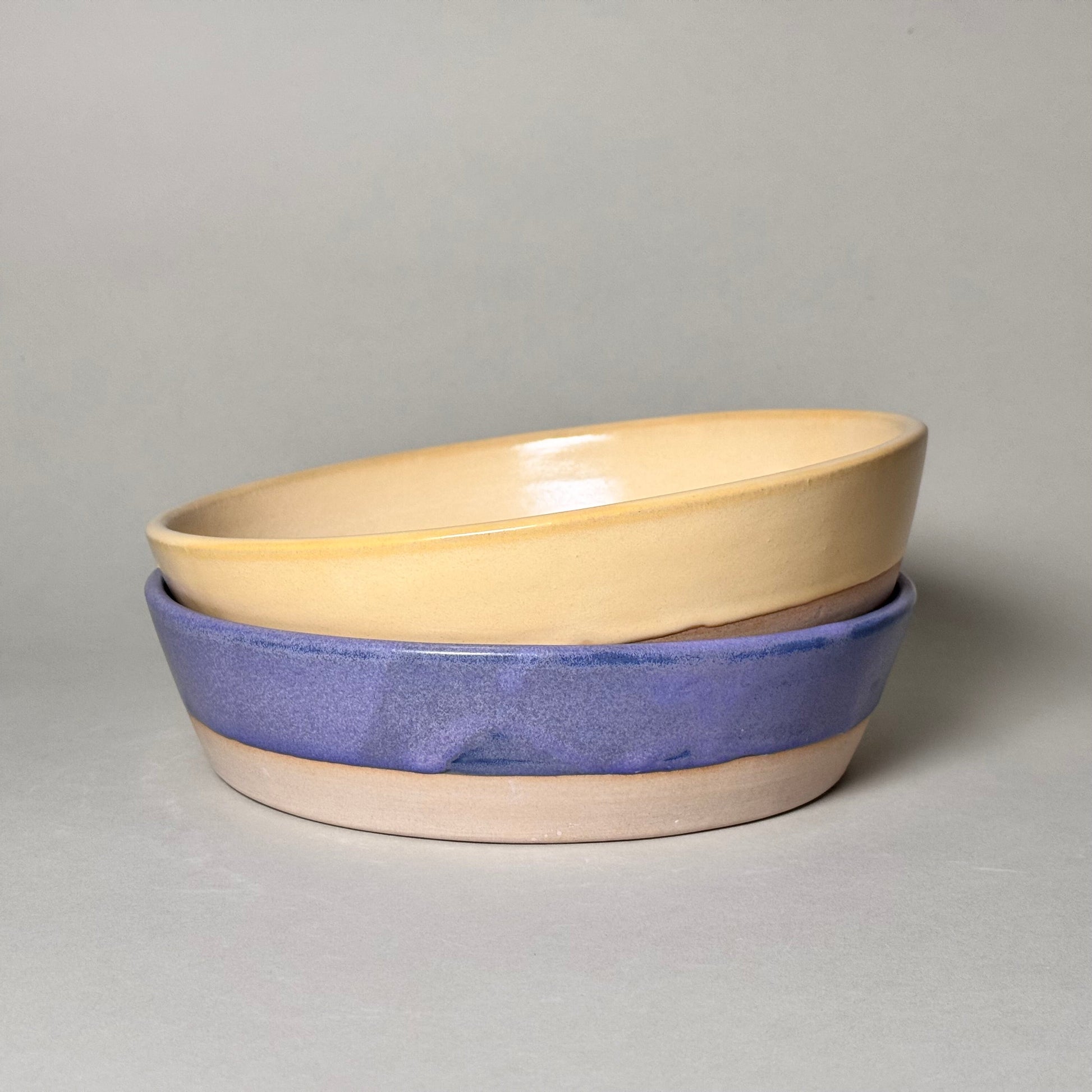 Share Bowl - 9-inch ceramic bowls stacked, beige interior with blue glaze exterior.