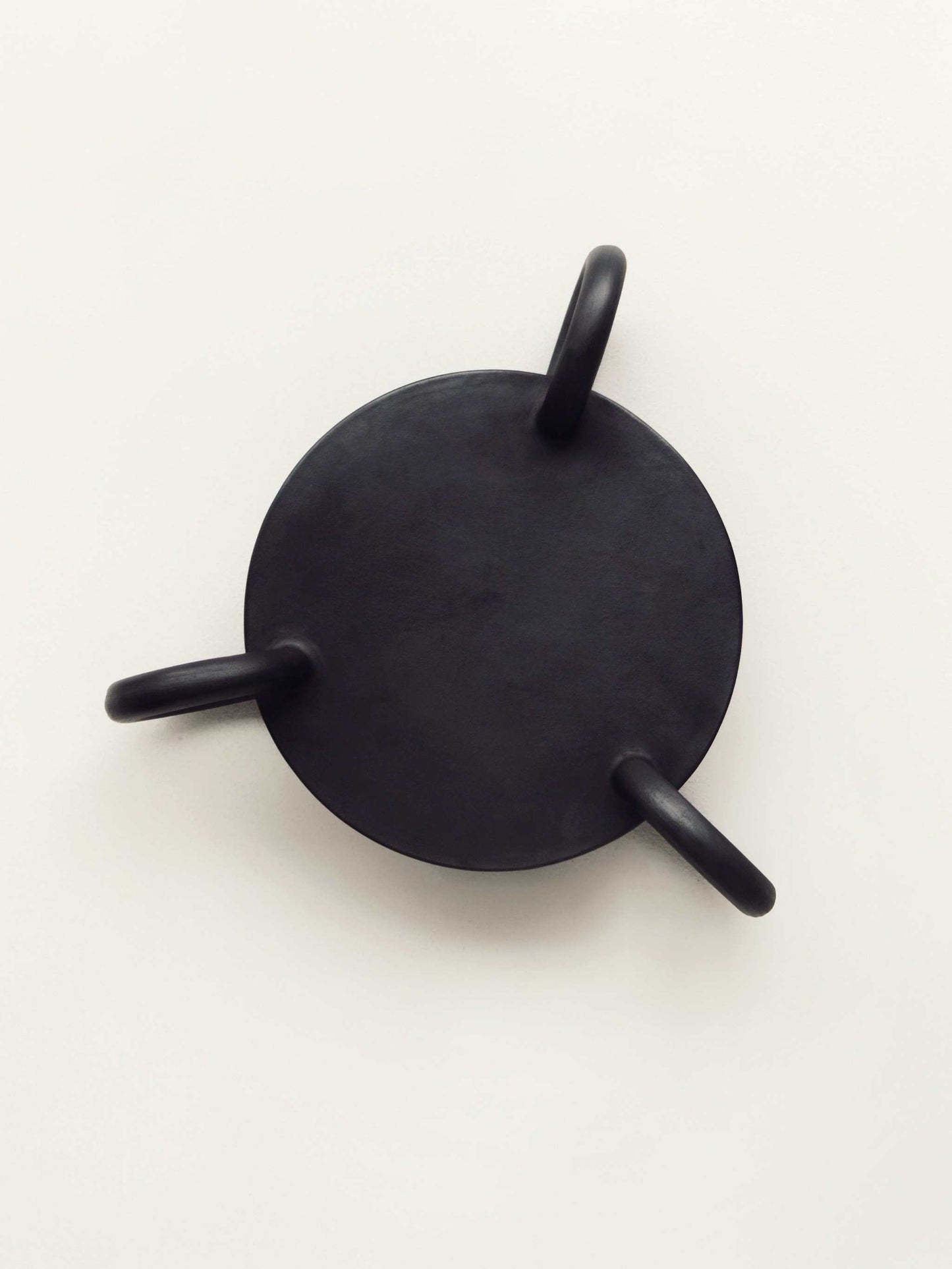 Large round Guculia Trinity serving platter with three handles in matte black.