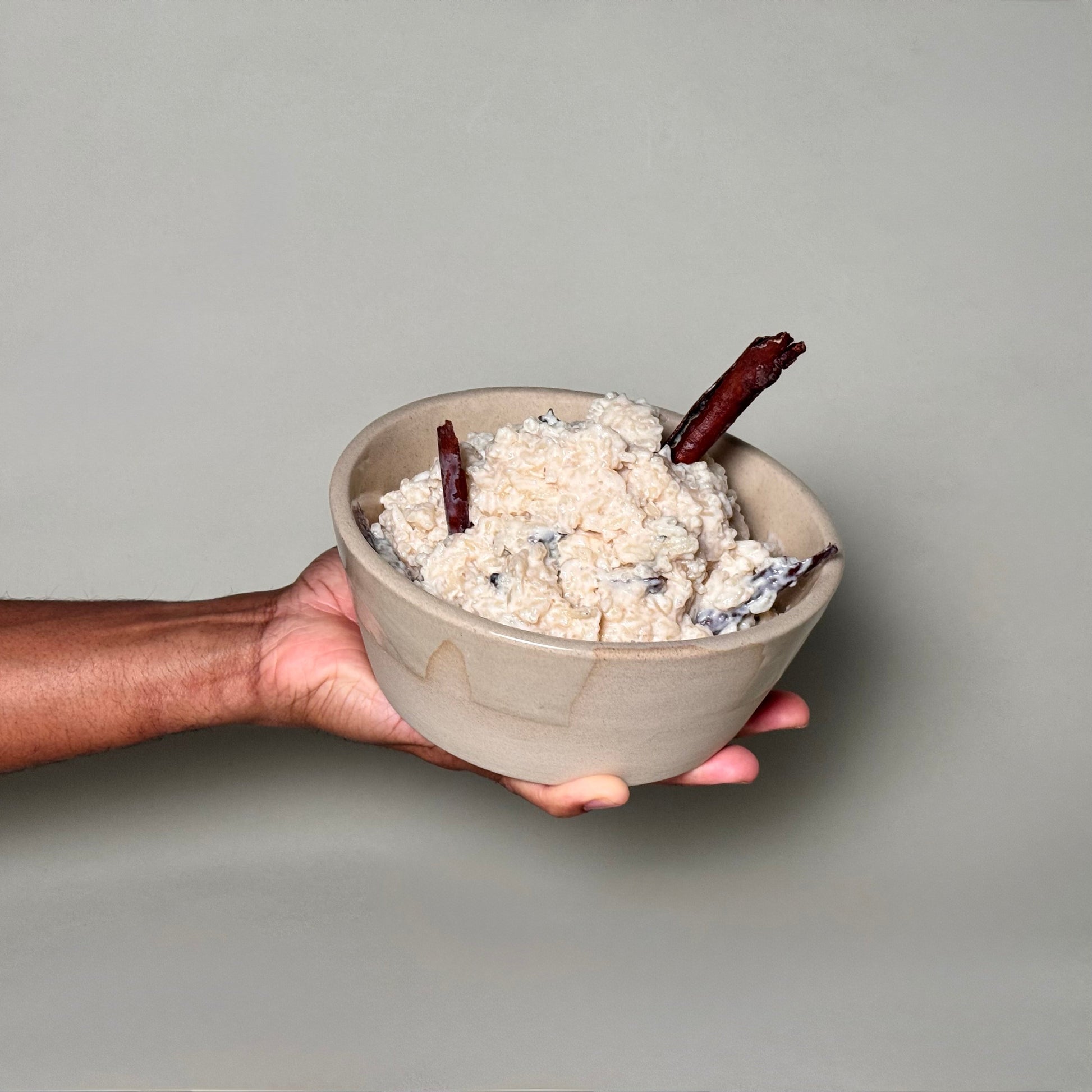 Soup Bowl - 6-inch ceramic bowl cradled in a hand, filled with creamy rice dish and cinnamon sticks.