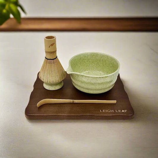 5 Piece Matcha Whisk Set on a LEIGH LEAF wooden display board with bamboo chasen, green ceramic bowl, and chashaku.
