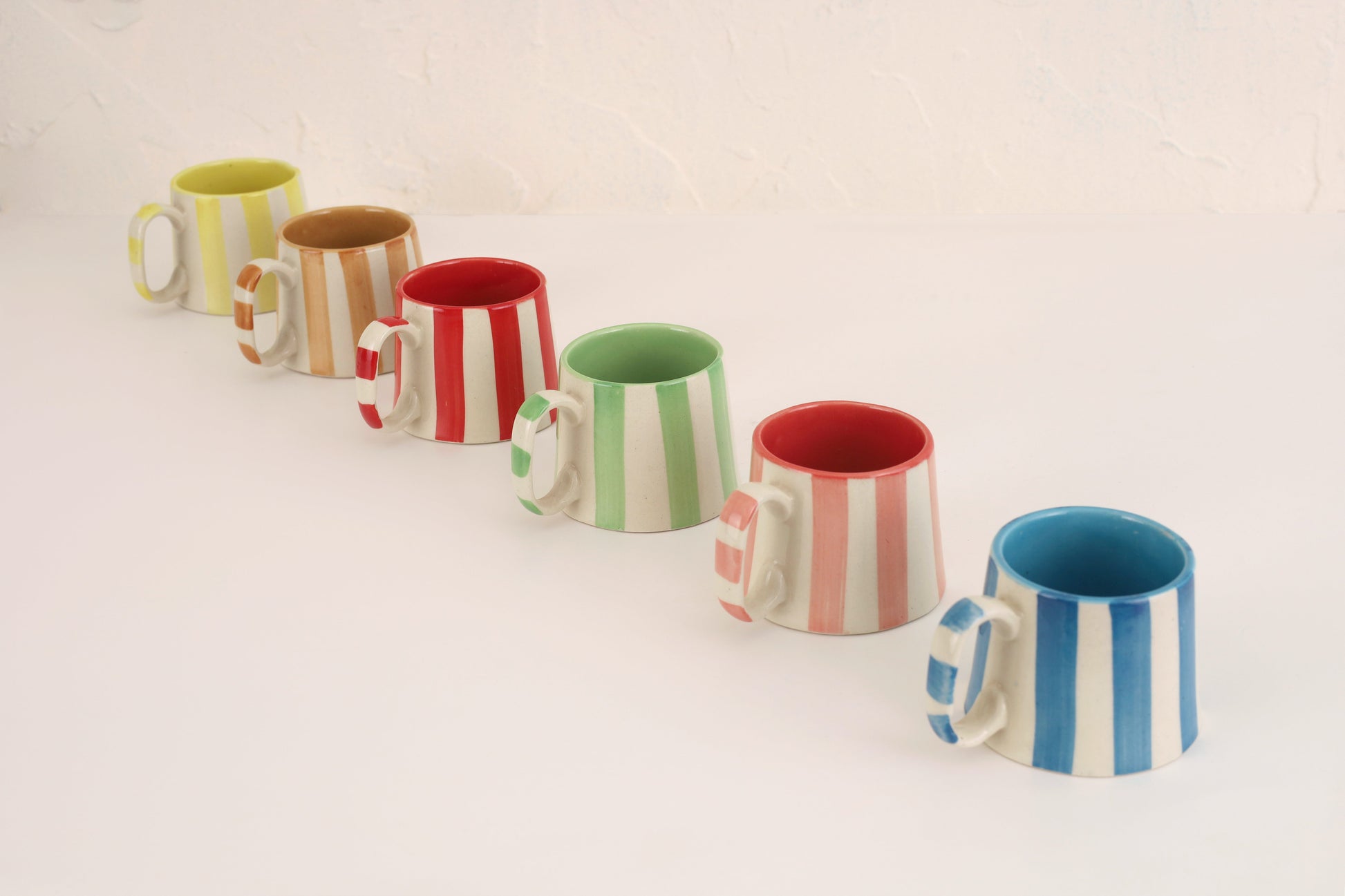 Ceramic Pink Stripe Coffee Cup set of 4, handcrafted mugs with vertical stripes, arranged diagonally.