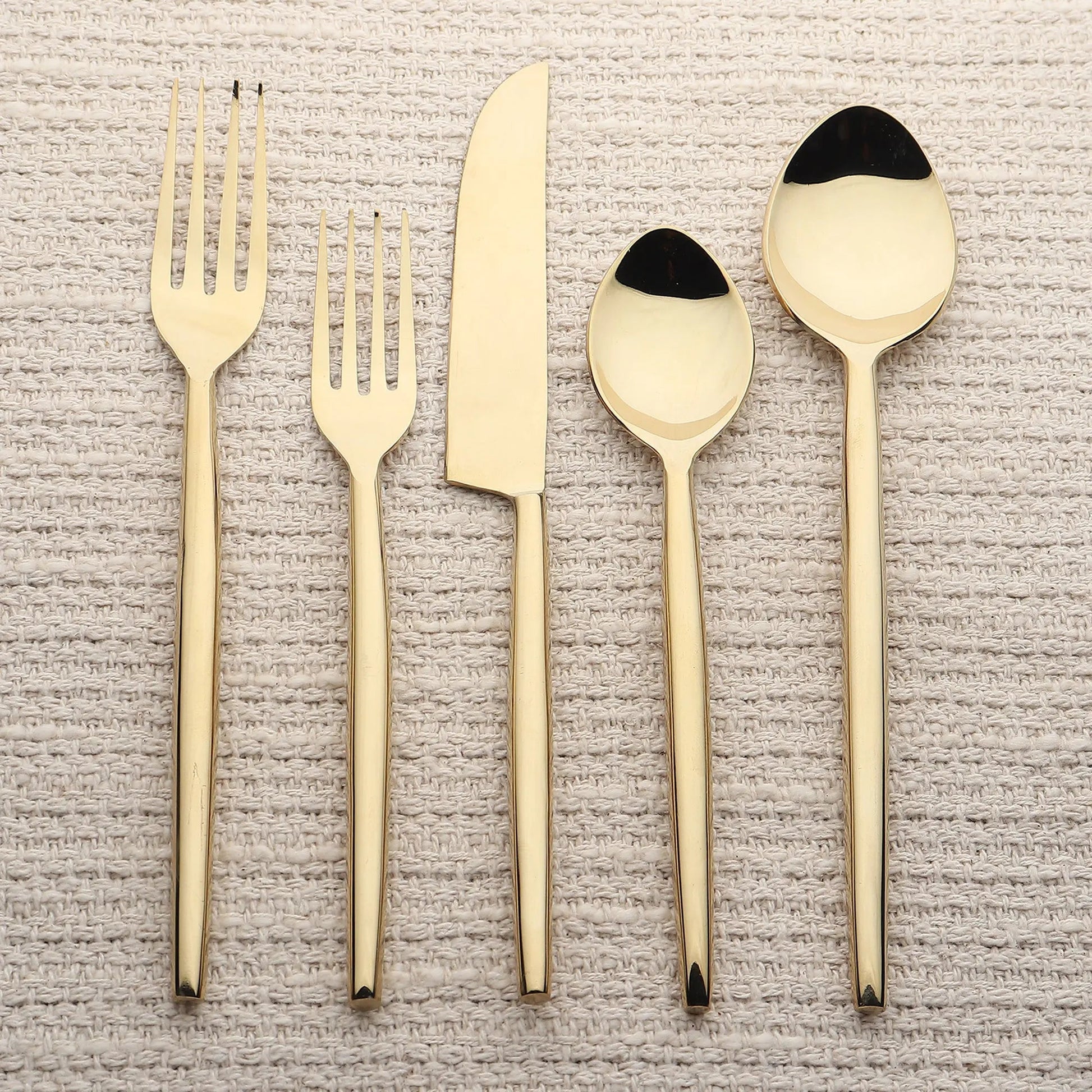 Brio PVD 5 Pc flatware set in gold-tone with slim tapered handles; includes forks, knife, tablespoon, and teaspoon.