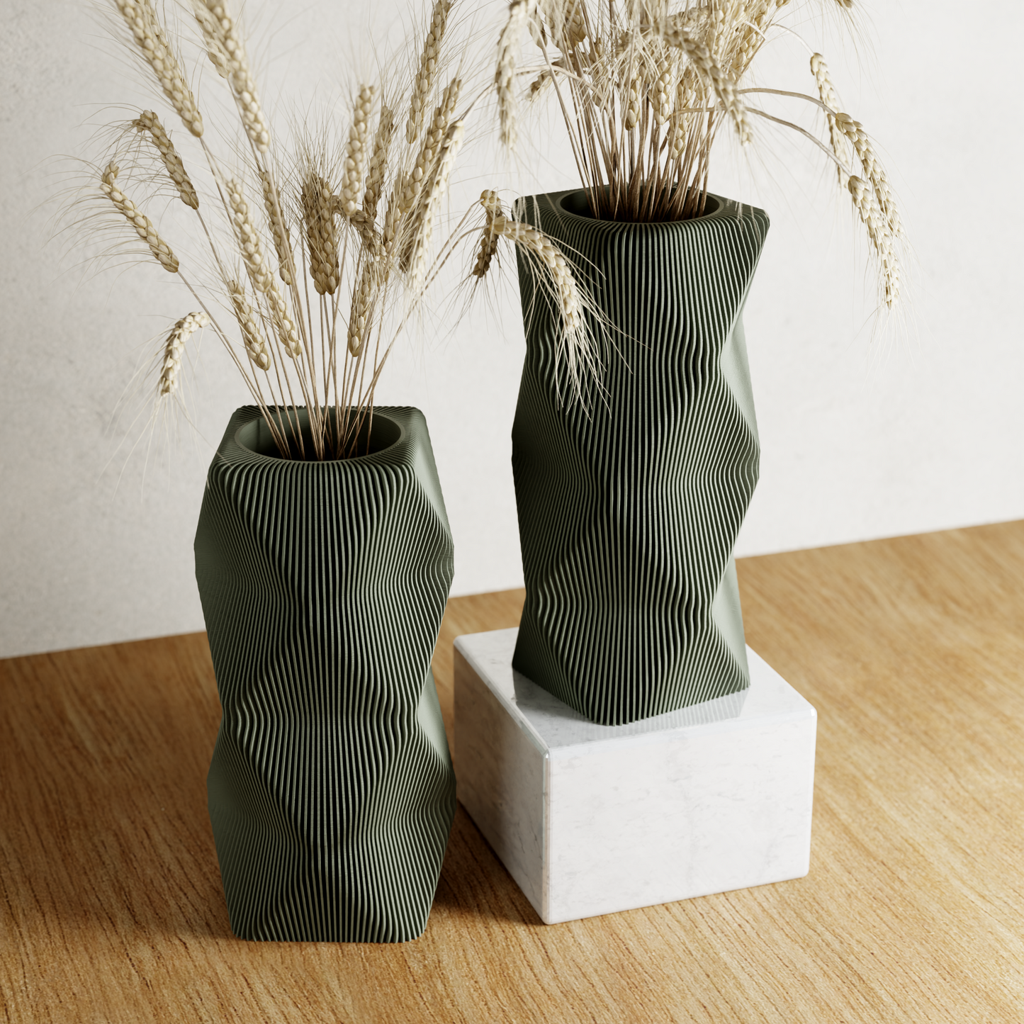 Two olive-green MOUNTAIN Vases with vertical ridges and dried stems on a wood table.