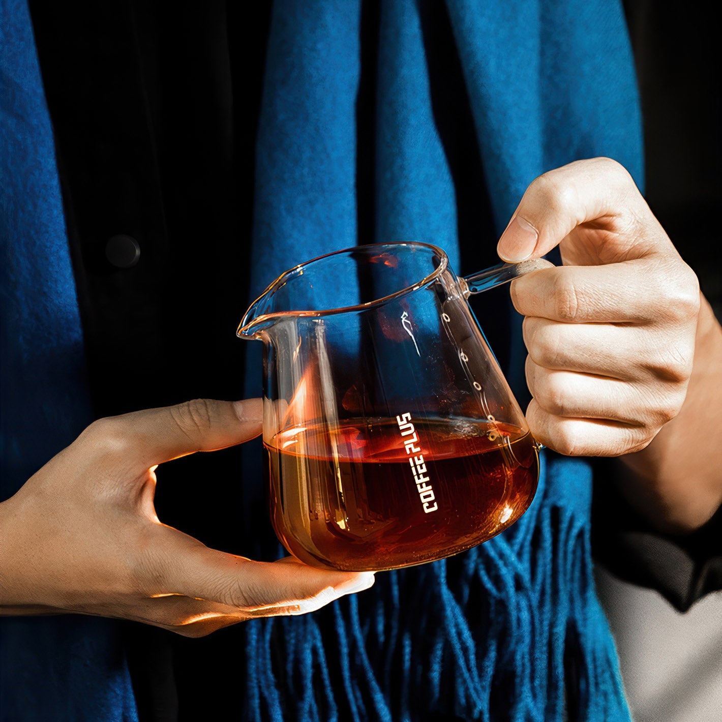 Glass coffee server carafe held in hands for hand-brew pour-over, clear borosilicate glass.