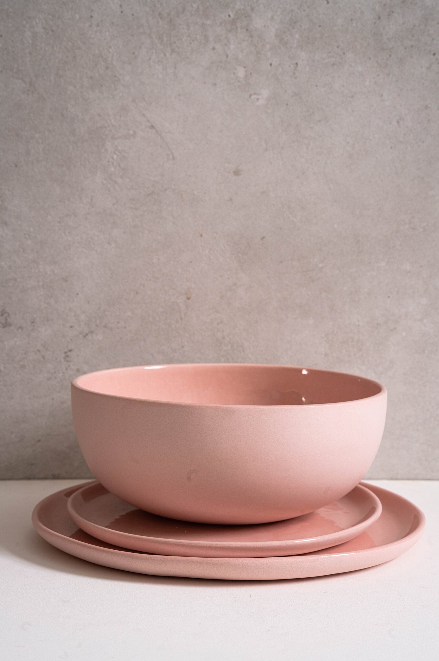 Powder pink handmade porcelain salad serving bowl with matching plates.