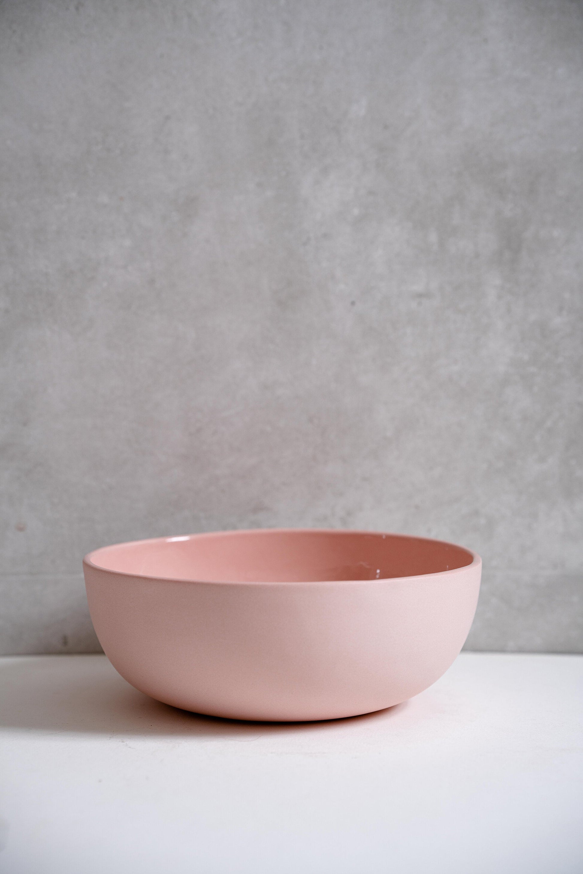 Powder Pink handmade porcelain salad serving bowl with a soft glaze on a white surface.