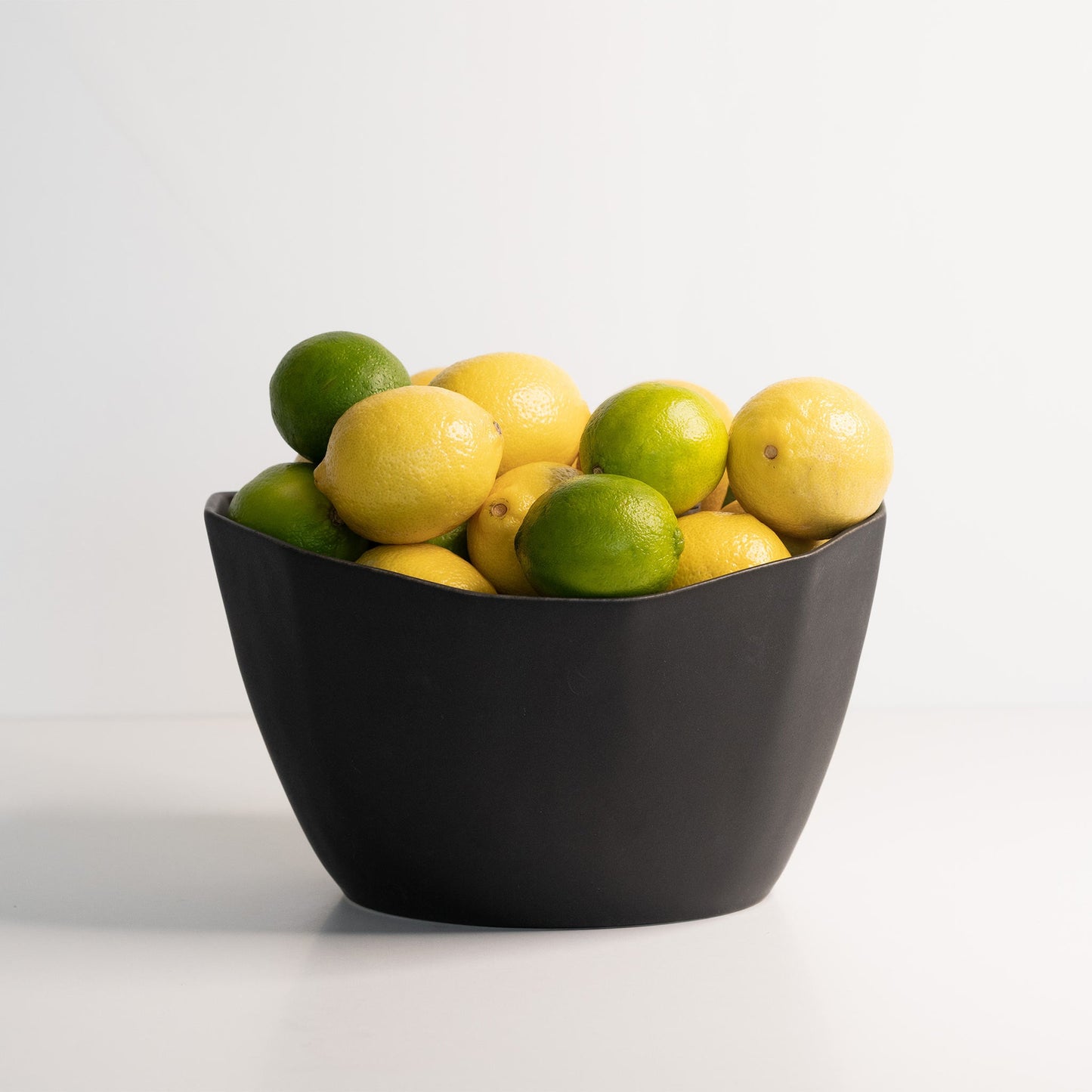 Medium Porcelain Nesting Bowl filled with lemons and limes.