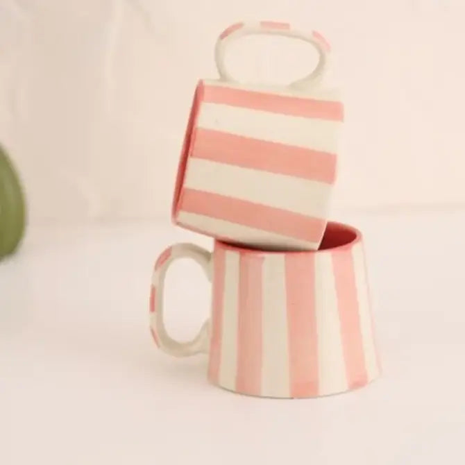 Set of four pink-striped ceramic coffee cups with wide openings.