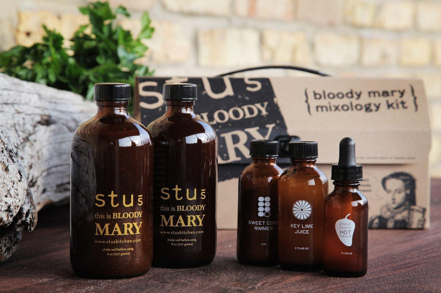 Stu's Bloody Mary Mixology Kit: brown glass bottles with labels and sauces in front of the boxed kit.