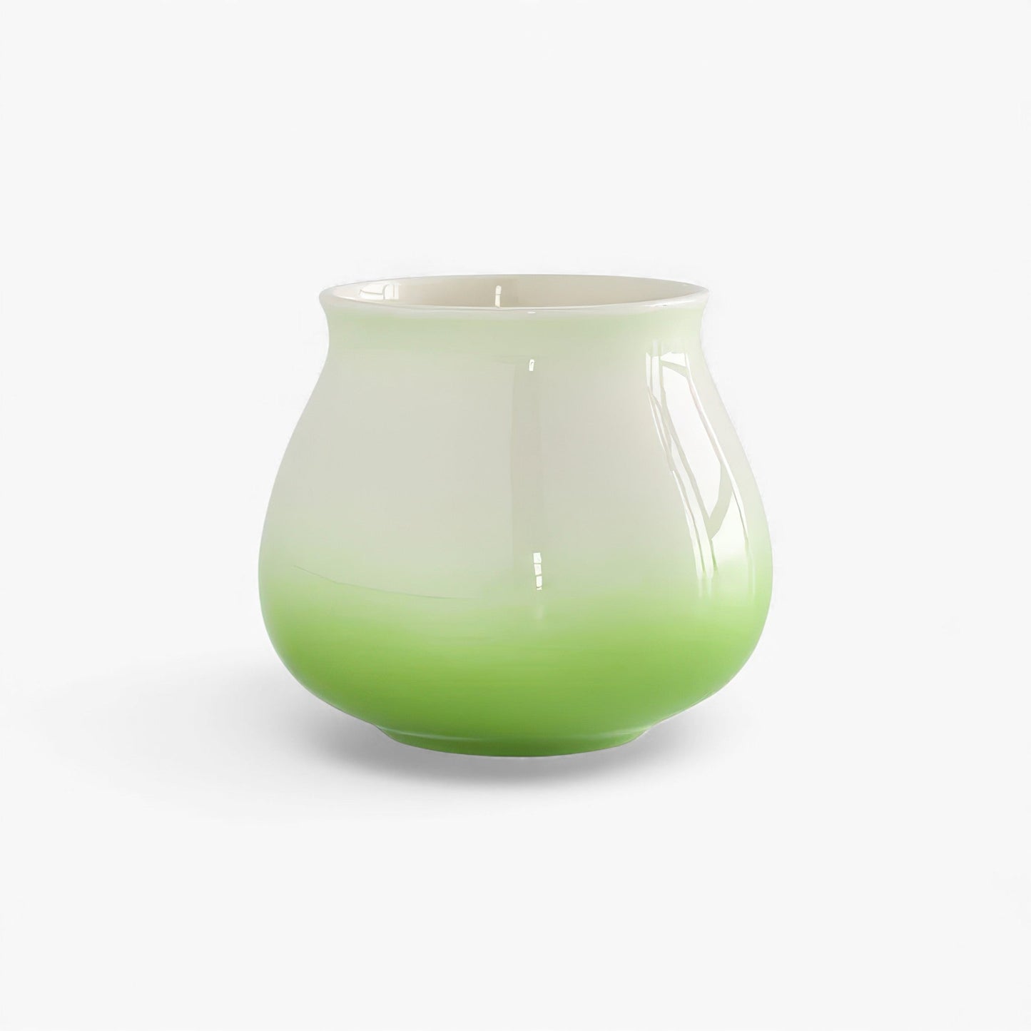 Ceramic gradient coffee cup with a green glaze at the base fading to white, wide mouth, and rounded hemispherical body.