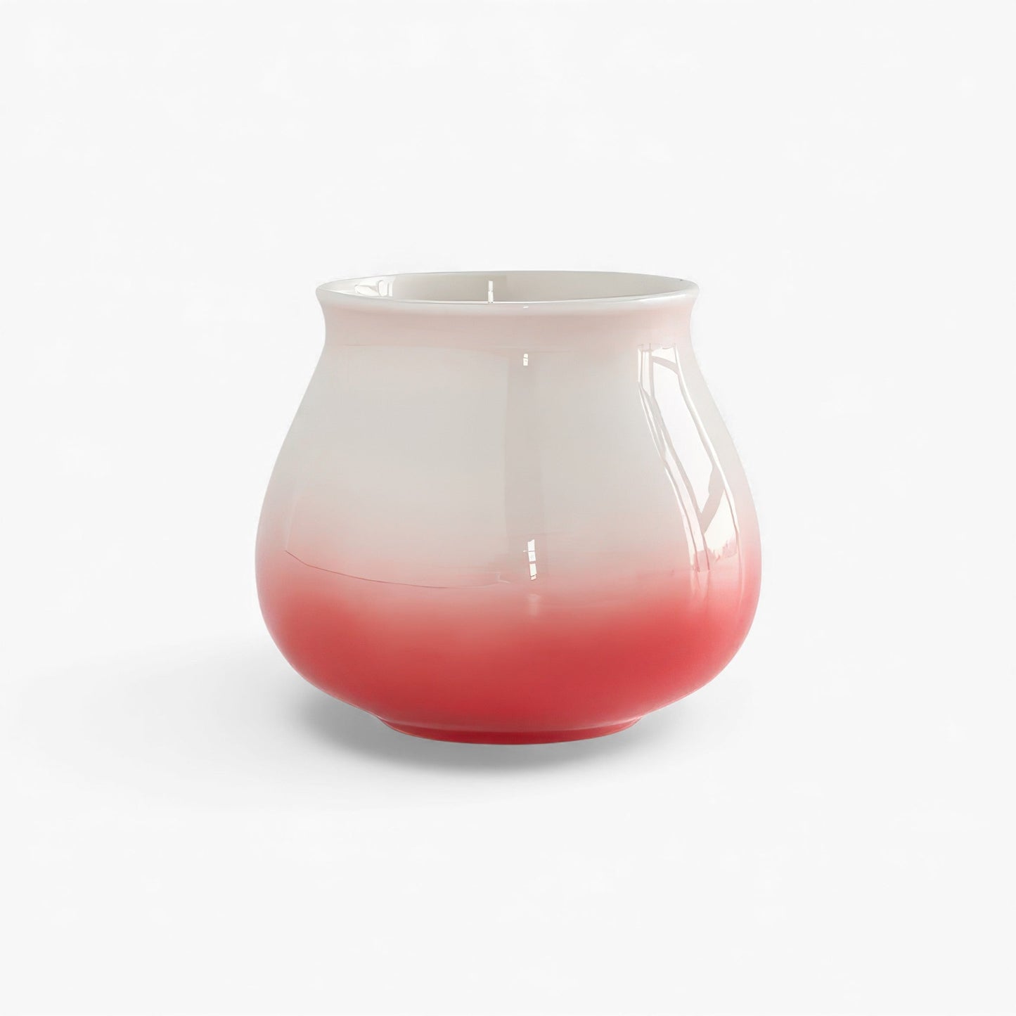 Ceramic gradient coffee cup with red base fading to pale pink, wide-mouth and hemispherical bottom.