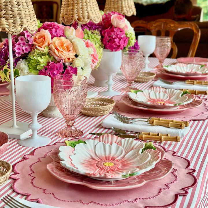 Harmony Pink Round Fabric Placemat on a pink striped table with floral centerpiece and pink dinnerware.