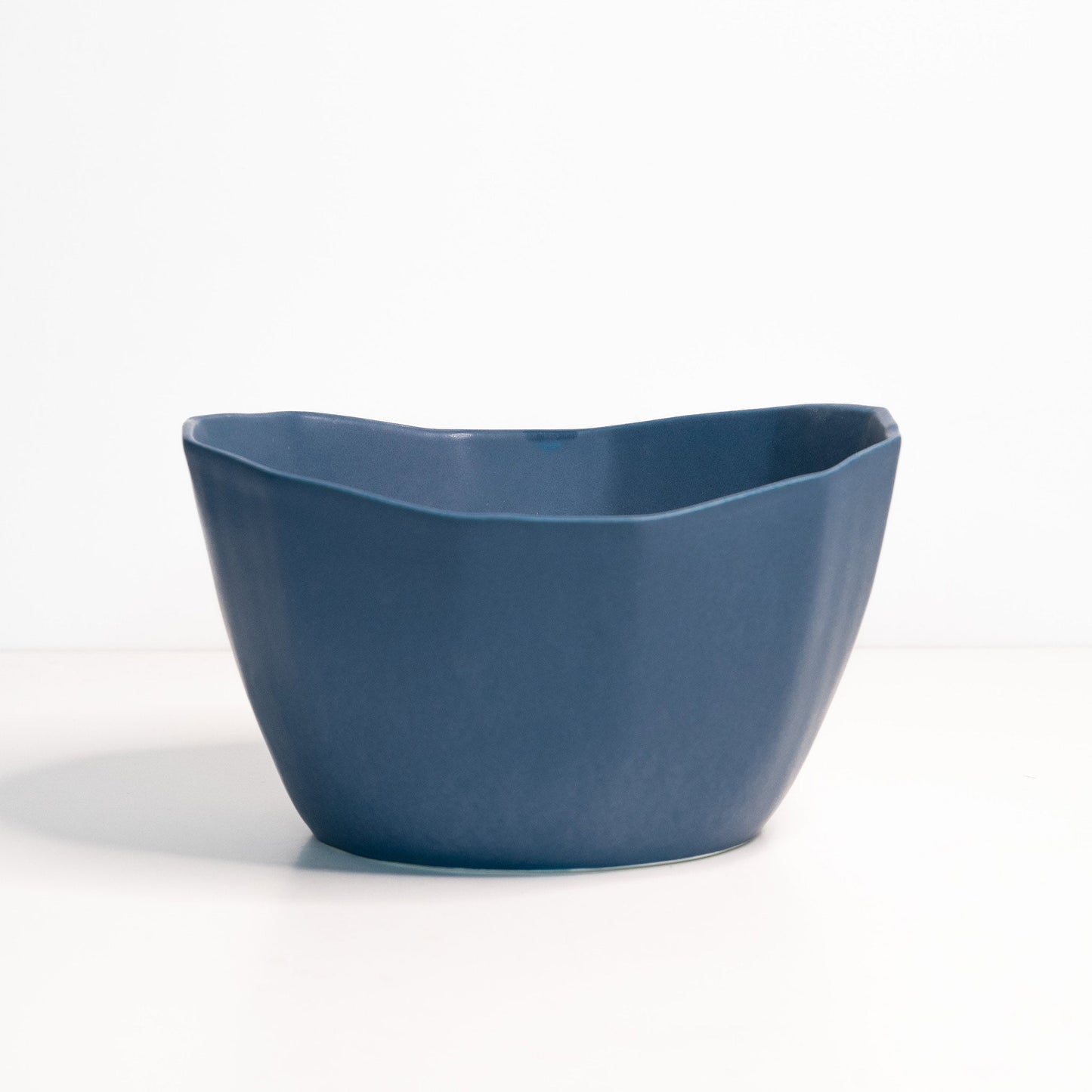 Ember Collective Medium Porcelain Nesting Bowl in blue, handmade with an organic, wavy rim.