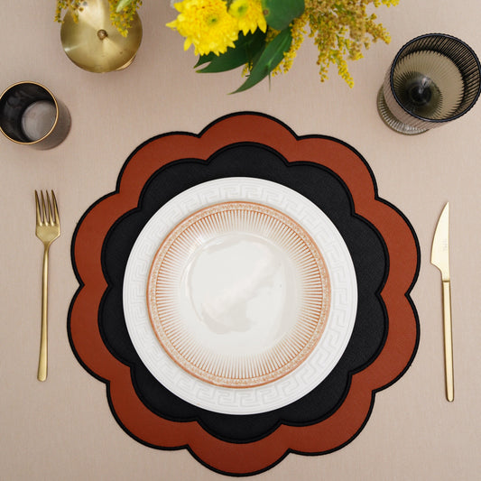 Serenity black-orange scalloped faux leather placemat with white plate and gold flatware.