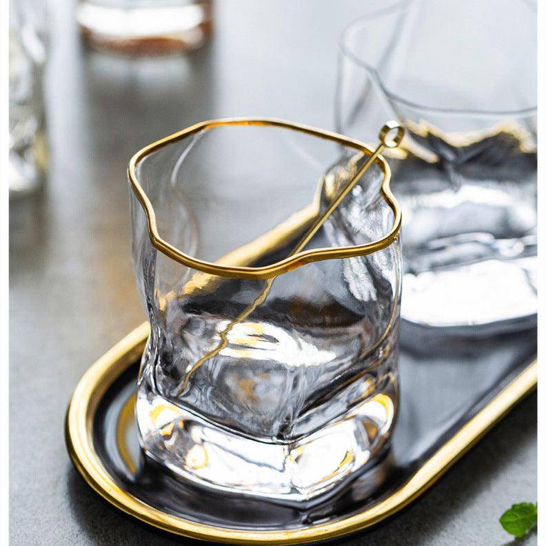 Gold Hoshi Japanese crystal whisky glass with textured exterior and gold-wire rim on a gold coaster.